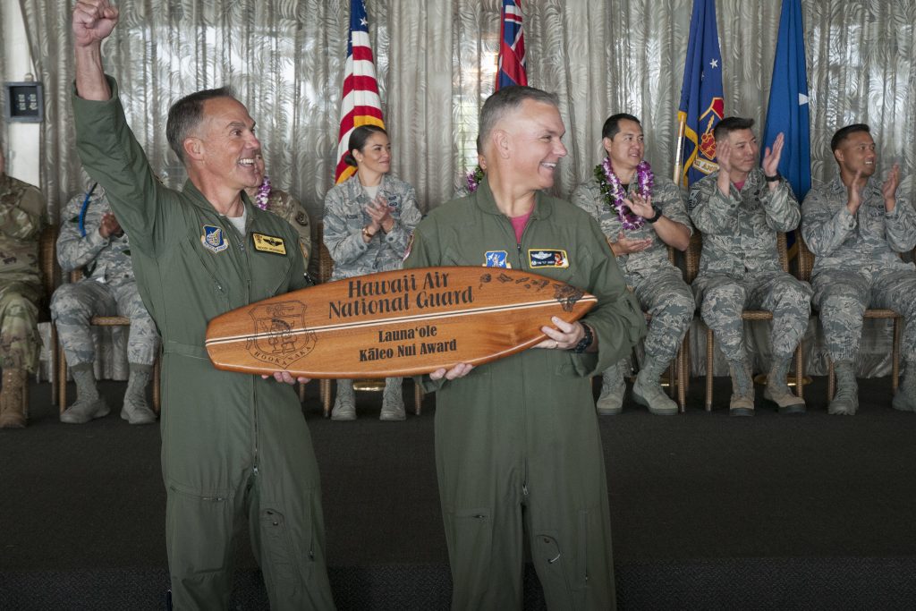 Brig. Gen. Gregory S. Woodrow, 154th Wing commander, and Col. Thomas James, 201st Air Operations Group commander, present the first Kaleo Nui Award Feb. 10, 2019, at Joint Base Pearl Harbor-Hickam. The award was handed off to representatives from the 154th Medical Group for their high-spirited cheers during the 2018 Launa’ole ceremony. In the Hawaiian language, Kaleo Nui means “the loud voice.” (U.S. Air National Guard photo by Senior Airman John Linzmeier)