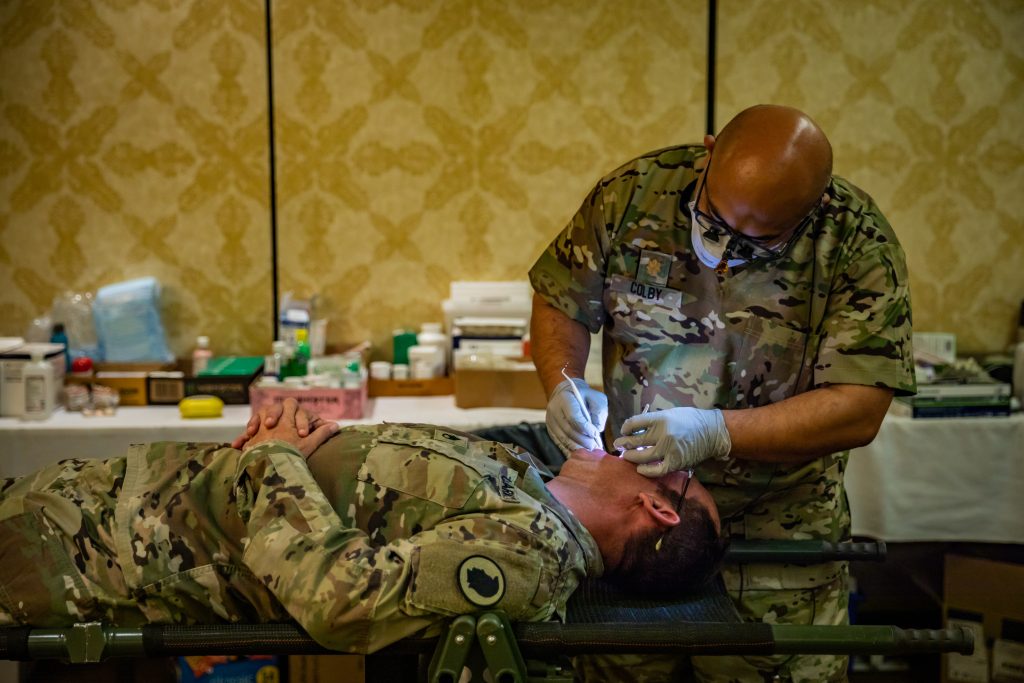 Hawaii Army National Guard Maj. Aaron Colby, right, a general dentist assigned to Charlie Company, Medical Detachment, 29th Infantry Brigade Combat Team and surgeon cell, Task Force Maui, Hawaii National Guard Joint Task Force-50 (HING JTF-50), conducts a dental exam on Staff Sgt. Matthew A. Foster, a mass communications specialist and platoon sergeant assigned to 117th Mobile Public Affairs Detachment, HING JTF-50, during the annual periodic health assessment in Lahaina, Maui, Oct. 14, 2023. In support of Maui County authorities, HING JTF-50, composed of the Hawaii Army and Air National Guard, is dedicated to the safety and recovery of affected Maui residents, coordinating with local first responders and adhering strictly to local, state and federal guidelines and laws. (U.S. Army National Guard photo by Sgt. Lianne M. Hirano)