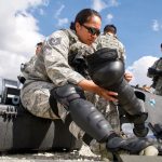 Tech Sgt. Tashalynn Willing, 154th Security Forces Squadron fire team member, puts on personal protective equipment during Patriot South exercise, Feb. 15, 2018, at Camp Shelby, Miss. The participating Airmen were temporarily ‘deputized’ by local police in order to serve as back-up support through the events of a simulated earthquake. (U.S. Air National Guard photo by Staff Sgt. James Ro)