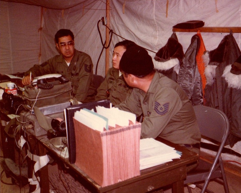 The 201st Combat Communications Group deployed to the annual Team Spirit exercises in Korea. The 201 CCG units augmented the existing communications system and setup communications on exercise bare bases. This photograph shows (L-R) Toshi Nagai, the then-297th Air Traffic Control Flight; Gregory Ing, the then-201st Combat Communications Flight, and an unidentified airman. There is even a hand crank field telephone in front of Greg.