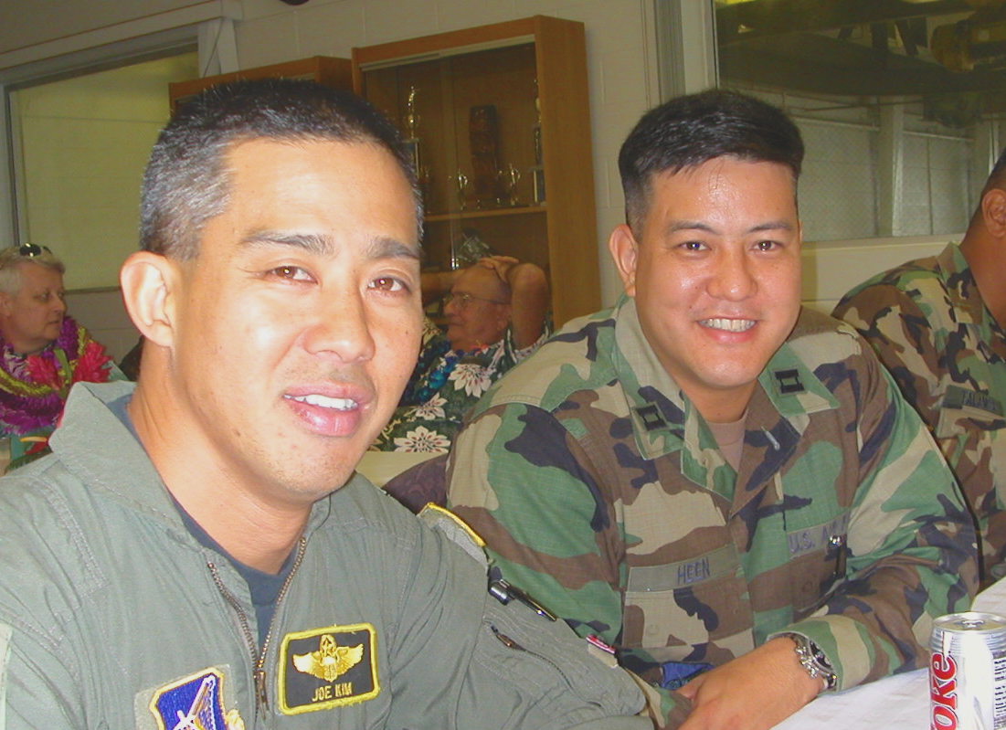 This undated photograph shows a young Joseph Kim and Cliff Heen. In the background is a lei bedecked Mick Melich, but we are unsure if this was his pinning celebration in 1997, or retirement party in the early 2000s.