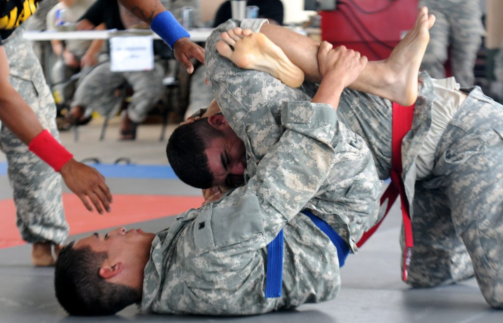 U.S. Army Pfc. Christopher Castro, Company Alpha, 29th Brigade Special Troops Battalion, performs a triangle headlock on Pfc. Paul-Zachary Barraza, Company Charlie, 29th Brigade Support Battalion during the Modern Army Combatives portion of the Hawaii Army National Guard Best Warrior Competition March 2, 2014 held at 298th Multi-Functional Regional Training Institute, Waimanalo, Hawaii. (U.S. Army National Guard photo by Staff Sgt. Ryan Sheldon/Released)