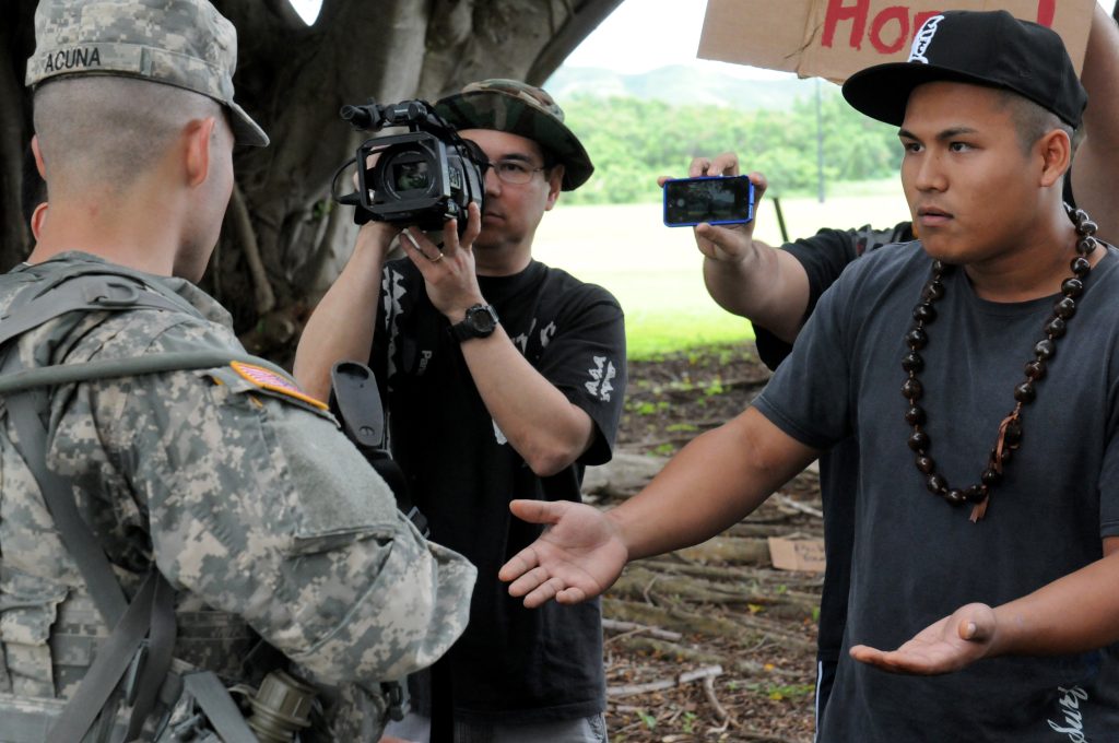 U.S. Army Pfc. Alvins Acuna-Campos, Company Bravo, 1109th Theater Aviation Sustainment Maintenance Group, engages civilians at the Rules of Engagement Army Warrior Task station during the Hawaii Army National Guard Best Warrior Competition March 1, 2014 held at 298th Multi-Functional Regional Training Institute, Waimanalo, Hawaii. (U.S. Army National Guard photo by Staff Sgt. Ryan Sheldon/Released)