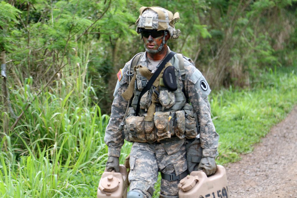 U.S. Army Spc. Paul Berzinas, assigned to the 117th Mobile Public Affairs Detachment, carries two five-gallon water cans while transitioning between events during the warrior tasks portion of the Hawaii Best Warrior Competition March 4, 2017. The grueling three-day competition tested Soldiers on numerous warrior tasks, and included several events designed to test each Soldier’s mental and physical endurance. Spc. Berzinas’ performance during the competition earned him the title of the 2017 Hawaii Army National Guard Soldier of the year.