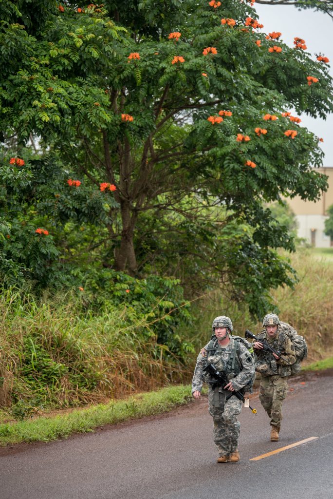 Staff Sgt. Krysta M. Waters of the 111th Army Band, 103rd Troop Command and Pfc. William I. Brady of 3rd Platoon, Alpha Troop, 1st Squadron, 299th Cavalry Regiment compete in the 12-mile ruck march during the Best Warrior Competition at Schofield Barracks, Hawaii Mar. 2, 2018. The Best Warrior Competition recognizes Soldiers who demonstrate commitment to the Army Values, embody the Warrior Ethos, and represent the Force of the Future.