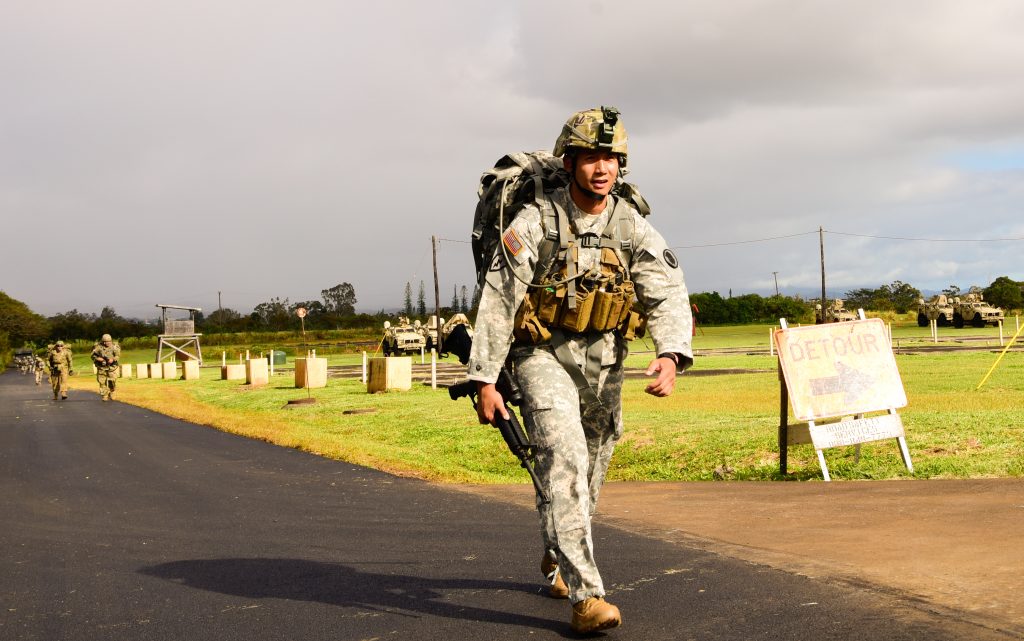 Staff Sgt. Paulo Napoles with the Recruiting and Retention Battalion, Hawaii Army National Guard road marches during the Best Warrior Competition on Schofield Barracks, Hawaii, March 1, 2019. Soldiers are challenged during this three-day competition involving a combat pistol qualification enabling Soldiers to engage targets while moving, an M4 qualification, land navigation, weapon assembly, road march, written exam, appearance board and multiple scenario-based warrior tasks. (Hawaii Army National Guard photo by Sgt. 1st Class Theresa Gualdarama)