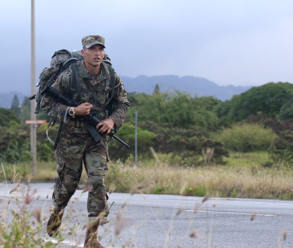 Hawaii Army National Guard Spc. Michael J. Makinano participates in the 2021 Hawaii Best Warrior Competition (BWC) 12 mile road march event at Pearl Harbor, Hawaii, March 6, 2021. The BWC is an annual three day event that Soldiers and Non-Commissioned Officers of the Hawaii Army National Guard and Hawaii Army Reserve compete in to earn the title of "Best Warrior". The BWC tests the Soldiers' individual ability to adapt and overcome challenging scenarios and battle-focused events, testing their technical and tactical skills under stress and extreme fatigue. (U.S. Army National Guard photo by Sgt. Lianne M. Hirano)