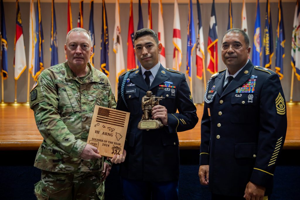 U.S. Army Brig. Gen. Stephen F. Logan, left, assistant adjutant general for the State of Hawaii, Hawaii Army National Guard (HIARNG), alongside Command Sgt. Maj. James R. Jimenez, right, command sergeant major of the HIARNG, award Spc. Andruw Nakamura, an infantryman assigned to Charlie Troop, 1st Squadron, 299th Cavalry Regiment, 9th Infantry Brigade Combat Team, HIARNG, for winning Soldier of the Year during the HIARNG 2024 Best Warrior Competition at the Regional Training Institute, Waimanalo, Hawaii, April 5-7, 2024. The Best Warrior Competition is an annual event conducted by the HIARNG to identify the most skilled and proficient Soldiers across various military occupational specialties (MOS). (U.S. Army National Guard photo by Sgt. Lianne M. Hirano)