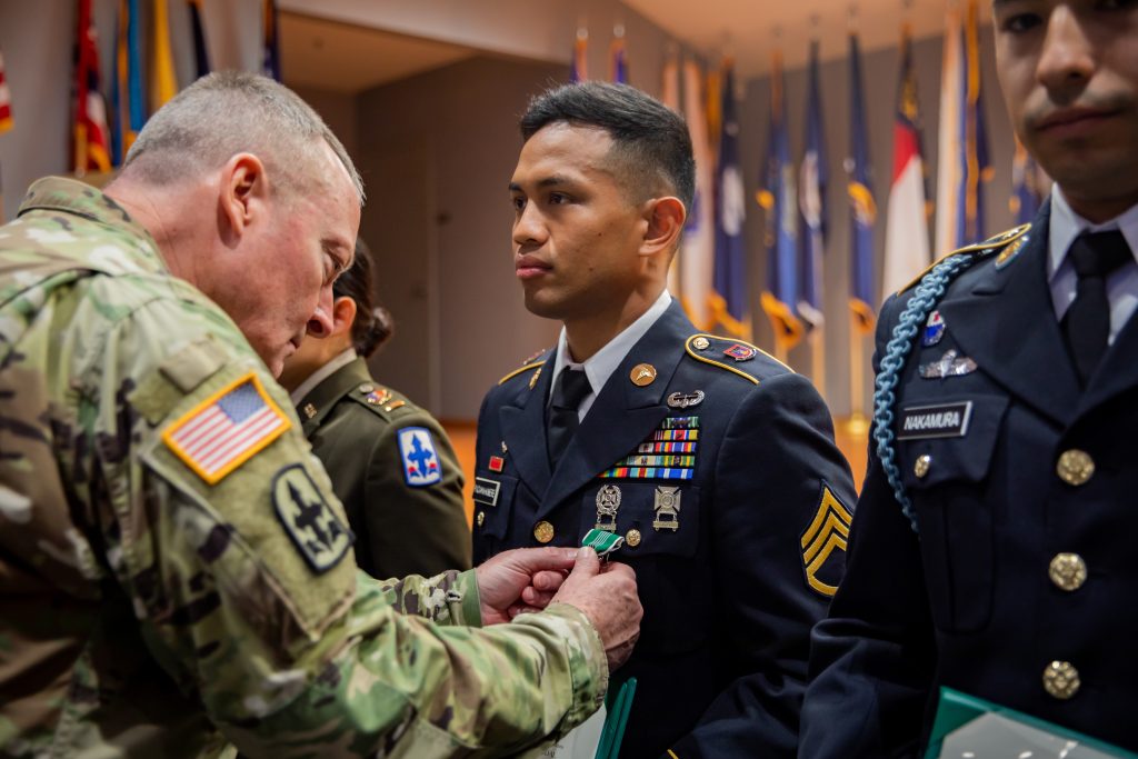U.S. Army Brig. Gen. Stephen F. Logan, left, assistant adjutant general for the State of Hawaii, Hawaii Army National Guard (HIARNG), awards Staff Sgt. Bradley Padama-Kinere, a combat medic specialist assigned to Headquarters Headquarters Battalion, 1st Battalion, 487th Field Artillery Regiment, 29th Infantry Brigade Combat Team, HIARNG, for winning Soldier of the Year during the HIARNG 2024 Best Warrior Competition at the Regional Training Institute, Waimanalo, Hawaii, April 5-7, 2024. The Best Warrior Competition is an annual event conducted by the HIARNG to identify the most skilled and proficient Soldiers across various military occupational specialties (MOS). (U.S. Army National Guard photo by Sgt. Lianne M. Hirano)