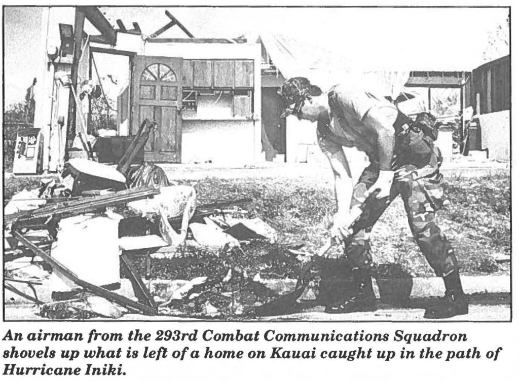 An airman from the 293rd Combat Communications Squadron shovels up what is left of a home on Kauai caught up in the path of Hurricane Iniki.