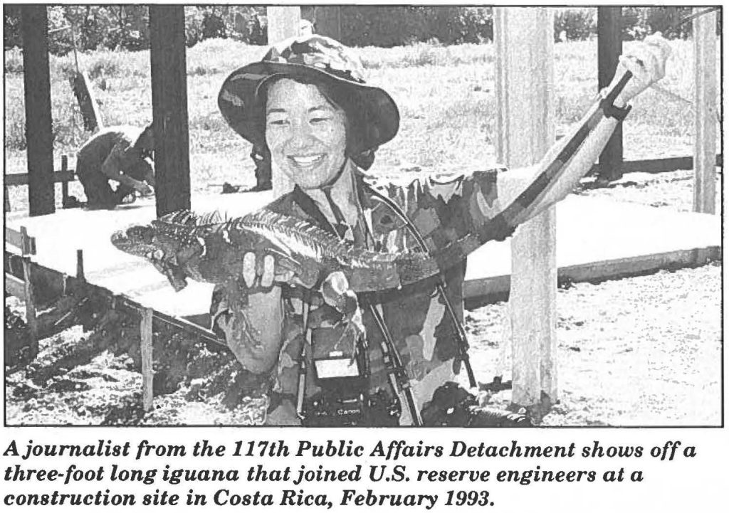 A journalist from the 117th Public Affairs Detachment shows off a three-foot long iguana that joined U.S. reserve engineers at a construction site in Costa Rica, February 1993.