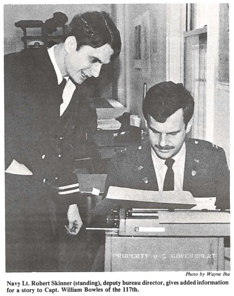 Navy Lt. Robert Skinner (standing), deputy bureau director, gives added information for a story to Capt. William Bowles of the 117th.