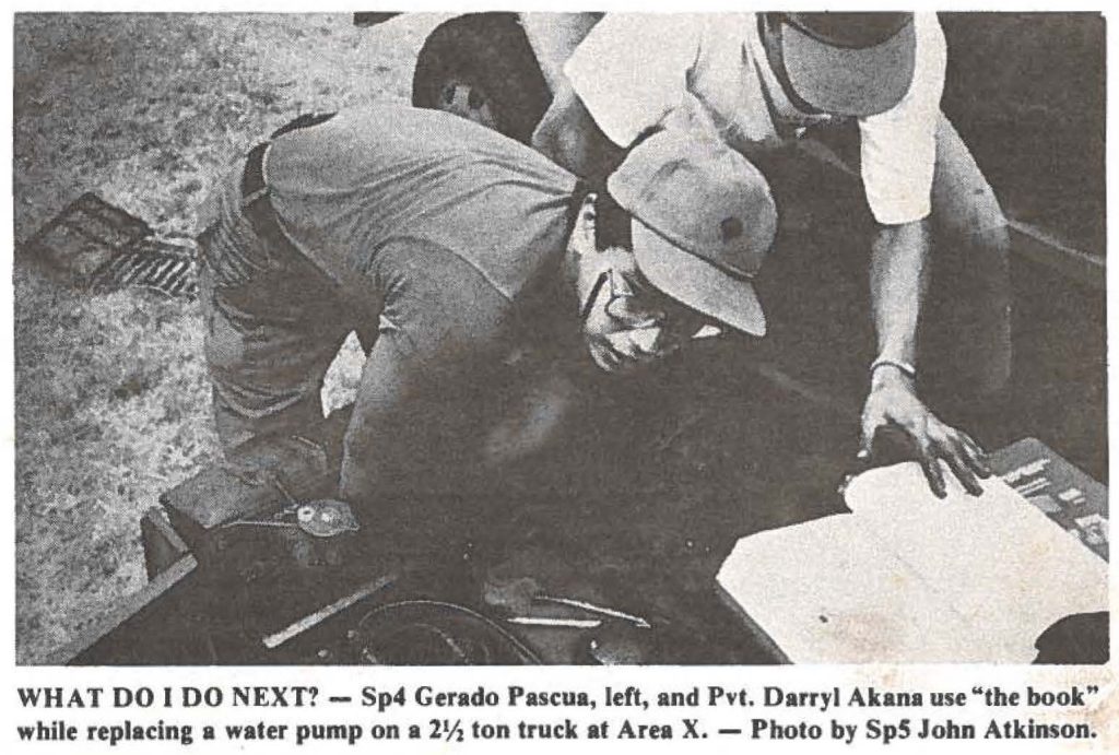 WHAT DO I DO NEXT? - Sp4 Gerado Pascua, left, and Pvt. Darryl Akana use .. the book" while replacing a water pump on a 2½ ton truck at Area X. - Photo by SpS John Atkinson.