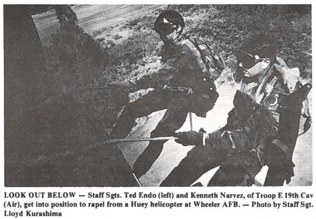 LOOK OUT BELOW - Staff Sgts. Ted Endo (left) and Kenneth Narvez, of Troop E 19th Cav (Air), get into position to rapel from a Huey helicopter at Wheeler AFB. - Photo by Staff Sgt. Lloyd Kurashima
