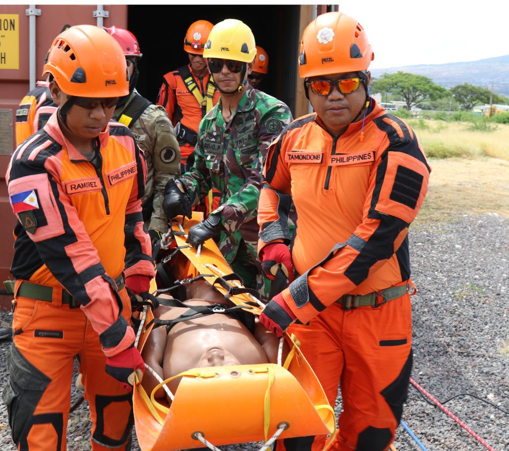 Soldiers of the Hawaii Army National Guard, Indonesian National Military - Quick Response Disaster Management Unit, and Philippines Army 525th Engineer Combat Battalion teams work together to simulate extraction of a casualty during a confined space rescue exercise in Kapolei, Hawaii, July 10, 2018. This marks the first joint training exercise between the HIARNG, Philippine, and Indonesian, Chemical, Biological, Radiological, Nuclear and High-Yield Explosive, Enhanced Response Force Package teams. (U.S. Army National Guard Photo by Sgt. Tinisha Mellein-Fortson/Released)