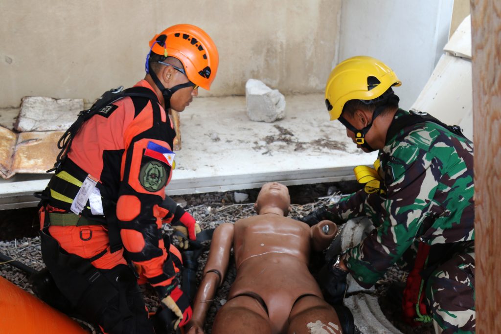 Soldiers of the Philippines Army 525th Engineer Combat Battalion and the Indonesian National Military - Quick Response Disaster Management Unit combine forces to assess a casualty during a confined space rescue exercise in Kapolei, Hawaii, July 10, 2018.This marks the first joint training exercise between the HIARNG, Philippine, and Indonesian, Chemical, Biological, Radiological, Nuclear and High-Yield Explosive, Enhanced Response Force Package teams. (U.S. Army National Guard Photo by Sgt. Tinisha Mellein-Fortson/Released)