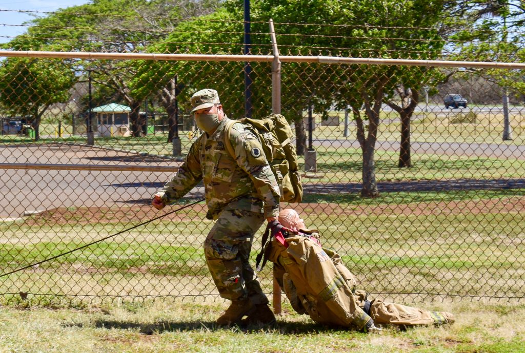 Sgt. Brandon Balala, a Carpenter with 230th Engineer Company, 103rd Troop Command, Hawaii Army National Guard, single-handedly drags a wounded manikin while conducting Tactical Combat Casualty Care (TC3) training during COVID-19 operations on the island of Maui, Kihei, Hawaii, May 15, 2020. Formerly called Combat Lifesaving, TC3 is divided into three phases: care under fire, tactical field care and combat casualty evacuation care. (U.S. Army National Guard photo by Sgt. 1st Class Theresa Gualdarama)