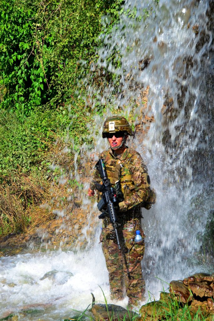 Second Lt. Cari Butler, a public affairs officer with the 117th Mobile Public Affairs Detachment, Hawaii Army National Guard, stands under a waterfall to cool off during a patrol near Check Point Naychin, Afghanistan, June 30, 2012. (Courtesy Photo)