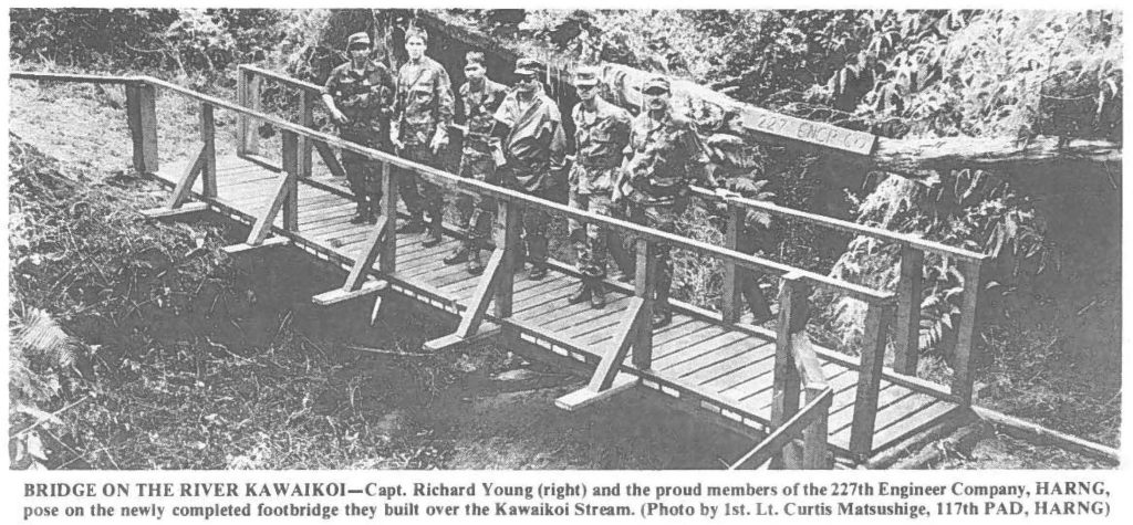 BRIDGE ON THE RIVER KAWAIKOI- Capt. Richard Young (right) and the proud member of the 227th Engineer Company, HARNG, pose on the newly completed footbridge they built over the Kawaikoi Stream. (Photo by 1st. Lt. Curtis Matsushige, 117th PAD, HARNG)