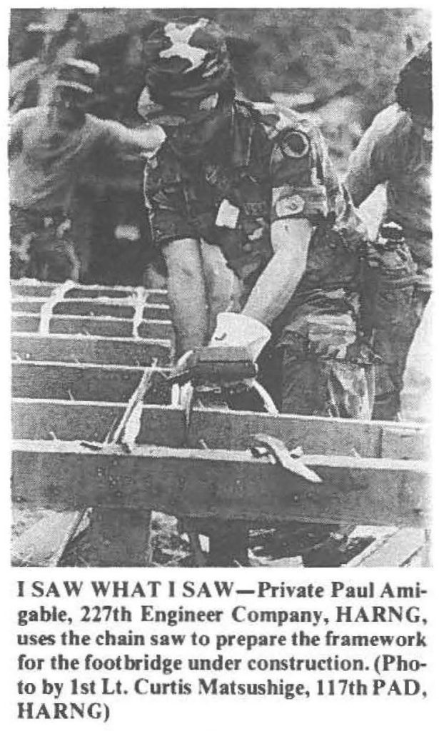 I SAW WHAT I SAW-Private Paul Amigable, 227th Engineer Company, HARNG, uses the chain saw to prepare the framework for the footbridge under construction. (Photo by 1st Lt. Curtis Matsushige, 117th PAD, HARNG)