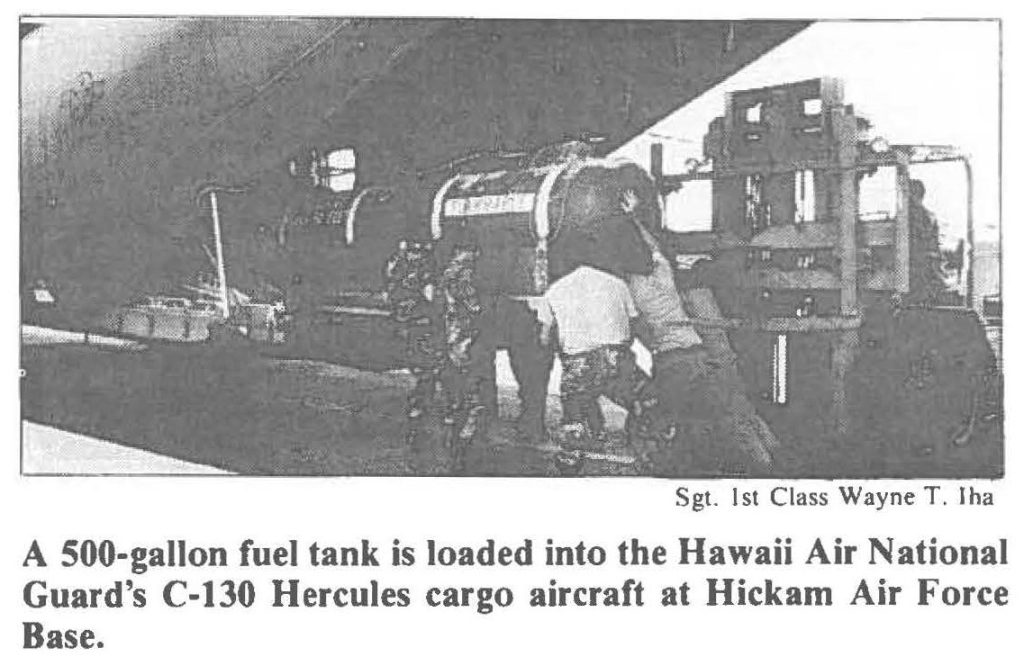 A 500-gallon fuel tank is loaded into the Hawaii Air National Guard's C-130 Hercules cargo aircraft at Hickam Air Force Base.