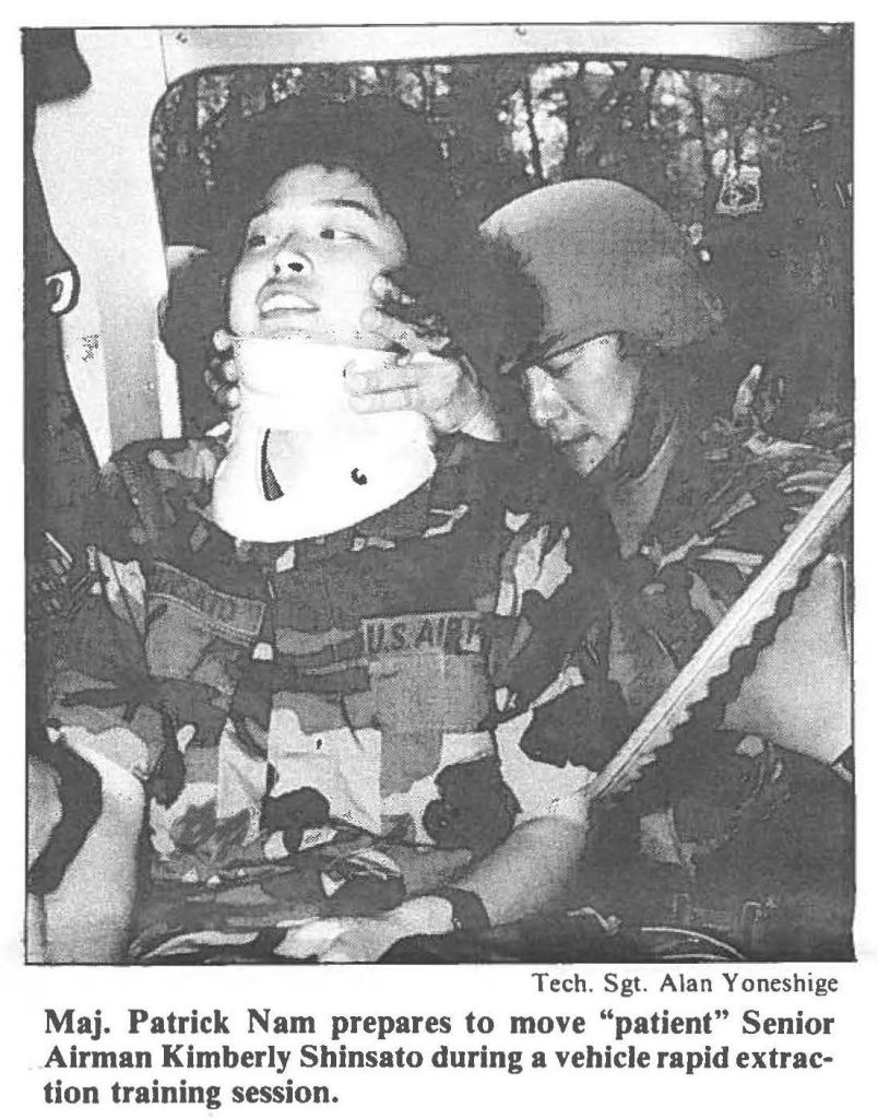 Maj. Patrick Nam prepares to move "patient" Senior Airman Kimberly Shinsato during a vehicle rapid extraction training session.