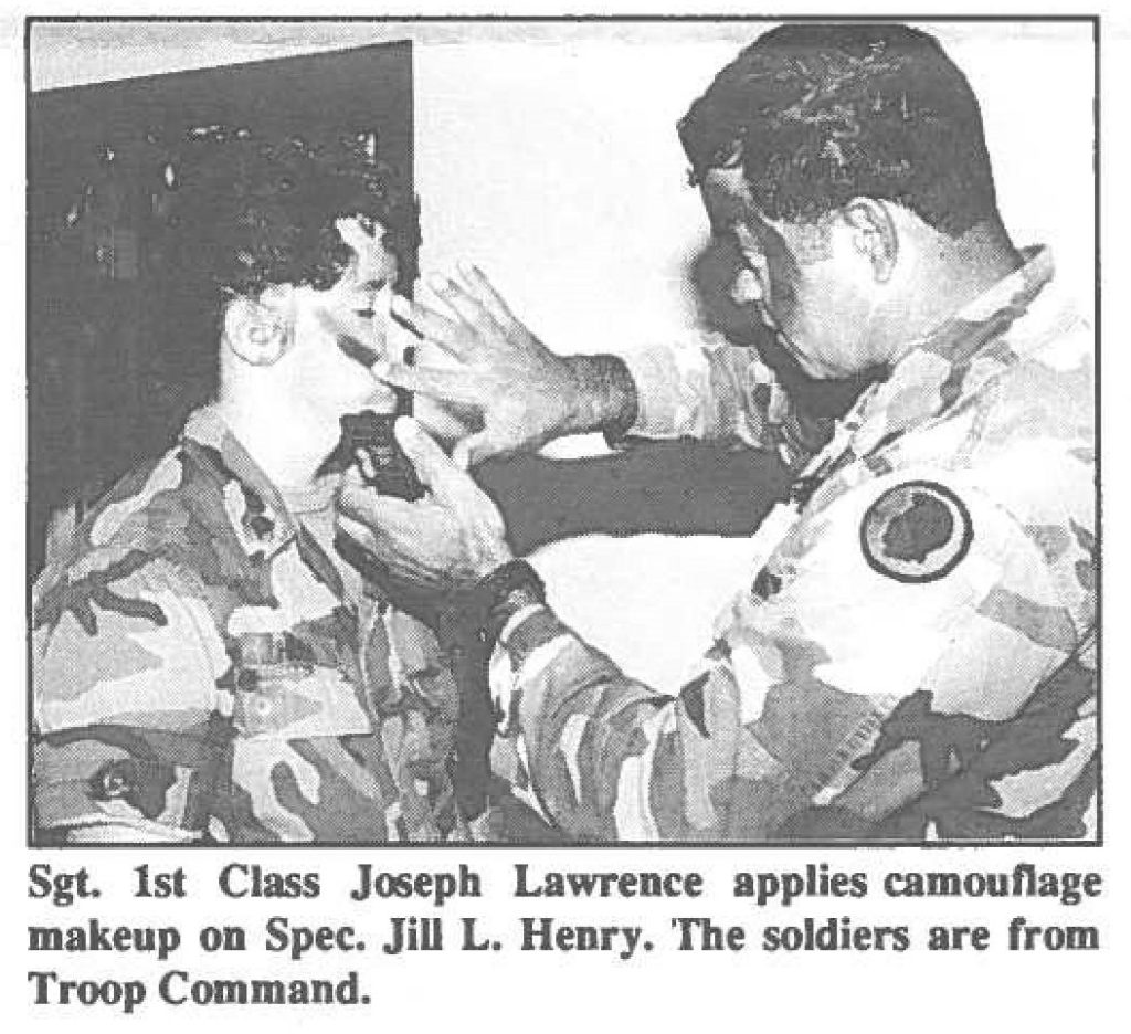 Sgt. 1st Class Joseph Lawrence applies camouflage makeup on Spec. Jill L. Henry. The soldiers are from Troop Command.