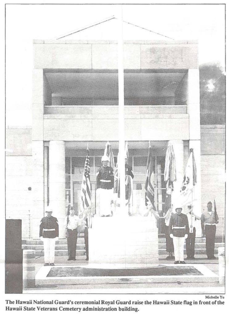 The Hawaii National Guard's ceremonial Royal Guard raise the Hawaii State flag in front of the Hawaii State Veterans Cemetery administration building