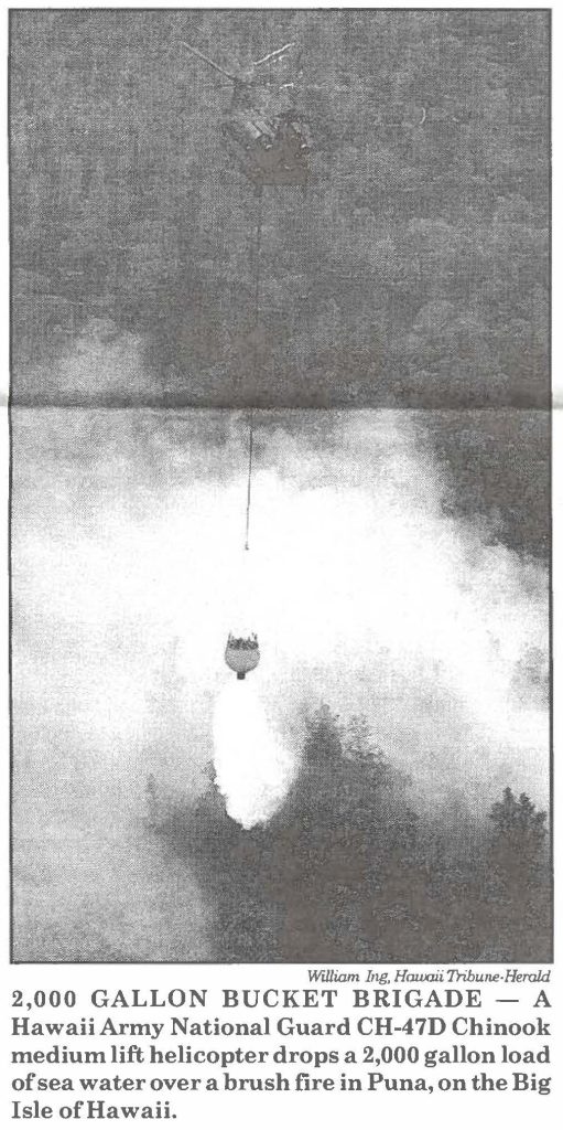 2,000 GALLON BUCKET BRIGADE - A Hawaii Army National Guard CH-4 7D Chinook medium lift helicopter drops a 2,000 gallon load of sea water over a brush fire in Puna, on the Big Isle of Hawaii.