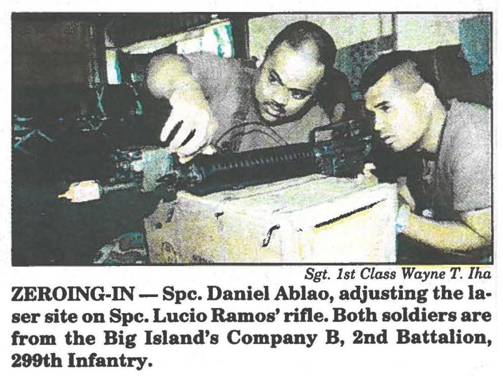 ZEROING-IN - Spc. Daniel Ablao, adjusting the laser site on Spc. Lucio Ramos' rifle. Both soldiers are from the Big Island's Company B, 2nd Battalion, 299th Infantry
