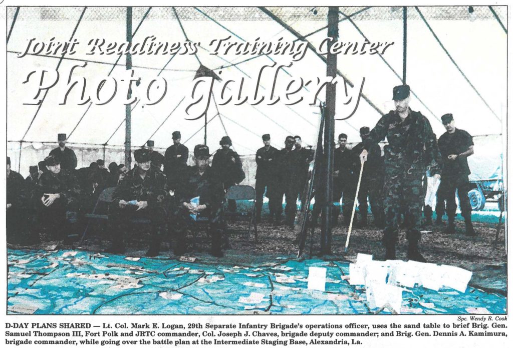 D-DAY PLANS SHARED - Lt. Col. Mark E. Logan, 29th Separate Infantry Brigade's operations officer, uses the sand table to brief Brig. Gen. Samuel Thompson m, Fort Polk and JRTC commander, Col. Joseph J. Chaves, brigade deputy commander; and Brig. Gen. Dennis A. Kamimura, brigade commander, while going over the battle plan at the Intermediate Staging Base, Alexandria, La.