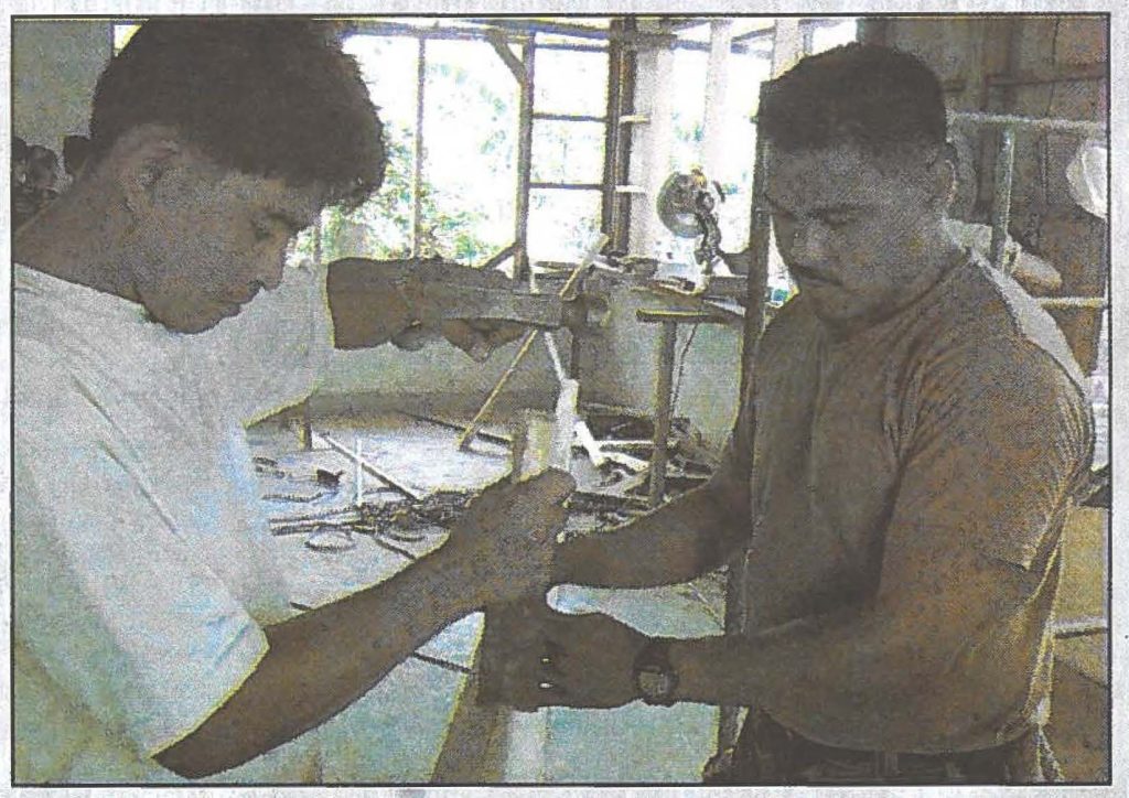TEAMWORKERS - Sgt. Joel Ballestro, 298th Engineer Detachment works with a local troop to make a "form" to be used for pouring cement during Exercise Balikatan in the Philippines.