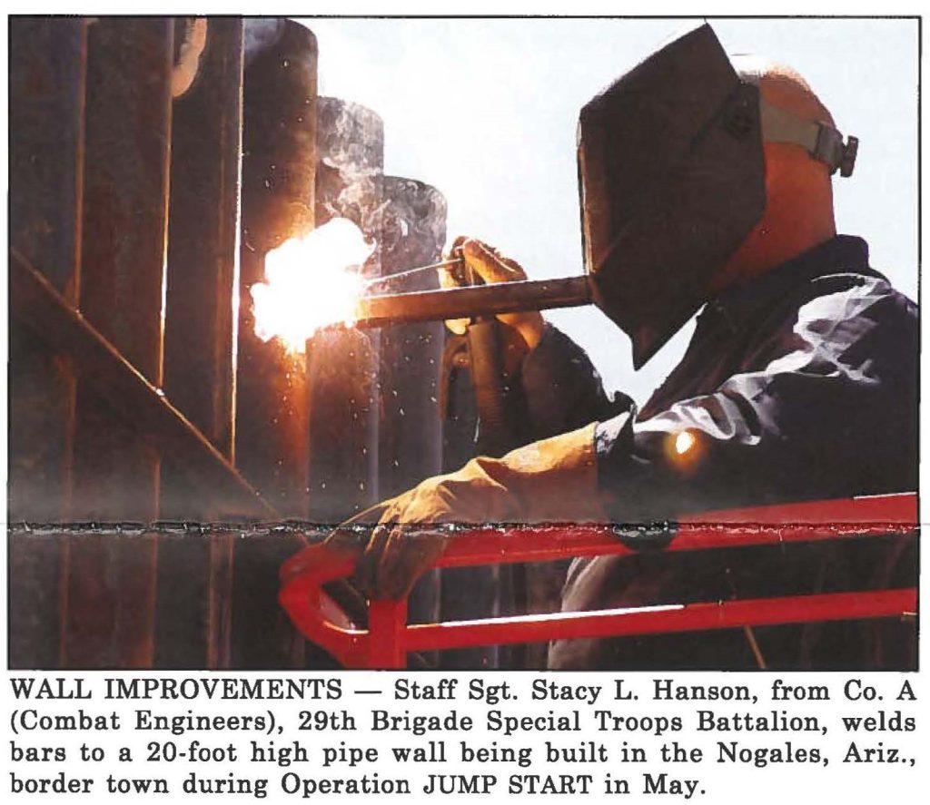 WALL IMPROVEMENTS - Staff Sgt. Stacy L. Hanson, from Co. A (Combat Engineers), 29th Brigade Special Troops Battalion, welds bars to a 20-foot high pipe wall being built in the Nogales, Ariz., border town during Operation JUMP START in May.