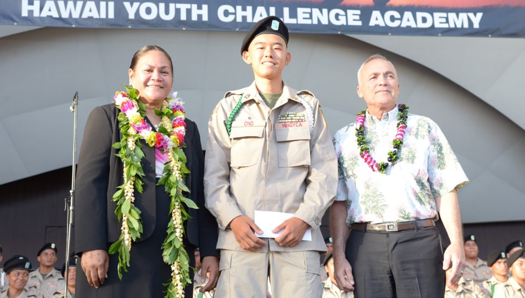 Youth Challenge Graduate Jaeden Ono received the first Col. Ron Han Scholarship at the Youth Challenge Kalaeloa graduation at the Waikiki Shell on Jun. 14, 2024. Graduate Ono will use his $2,500 scholarship to attend Leeward Community College and major in Information and Computer Science. The late Col. Ron Han served Hawai‘i as the director of the State Office of Veterans’ Services for over a decade. Col Han passed away in August of 2023. Pictured from L-R is YCA Kalaeloa Director Sina Atanoa, Graduate Jaeden Ono, and Director of the Civilian Military Program Division, Brig. Gen. (Ret) Bruce Oliveira.