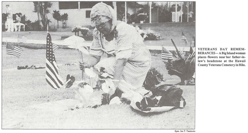 VETERANS DAY REMEMBERANCES-• A Big Island woman places flowers near her father-in law's headstone at the Hawaii County Veterans Cemetery in Hilo.